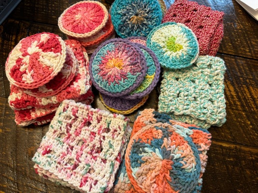 Collection of colorful crocheted squares on a wooden surface