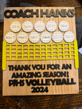 Wooden plaque with engraved text and volleyball design, likely a gift for Coach Hanks.