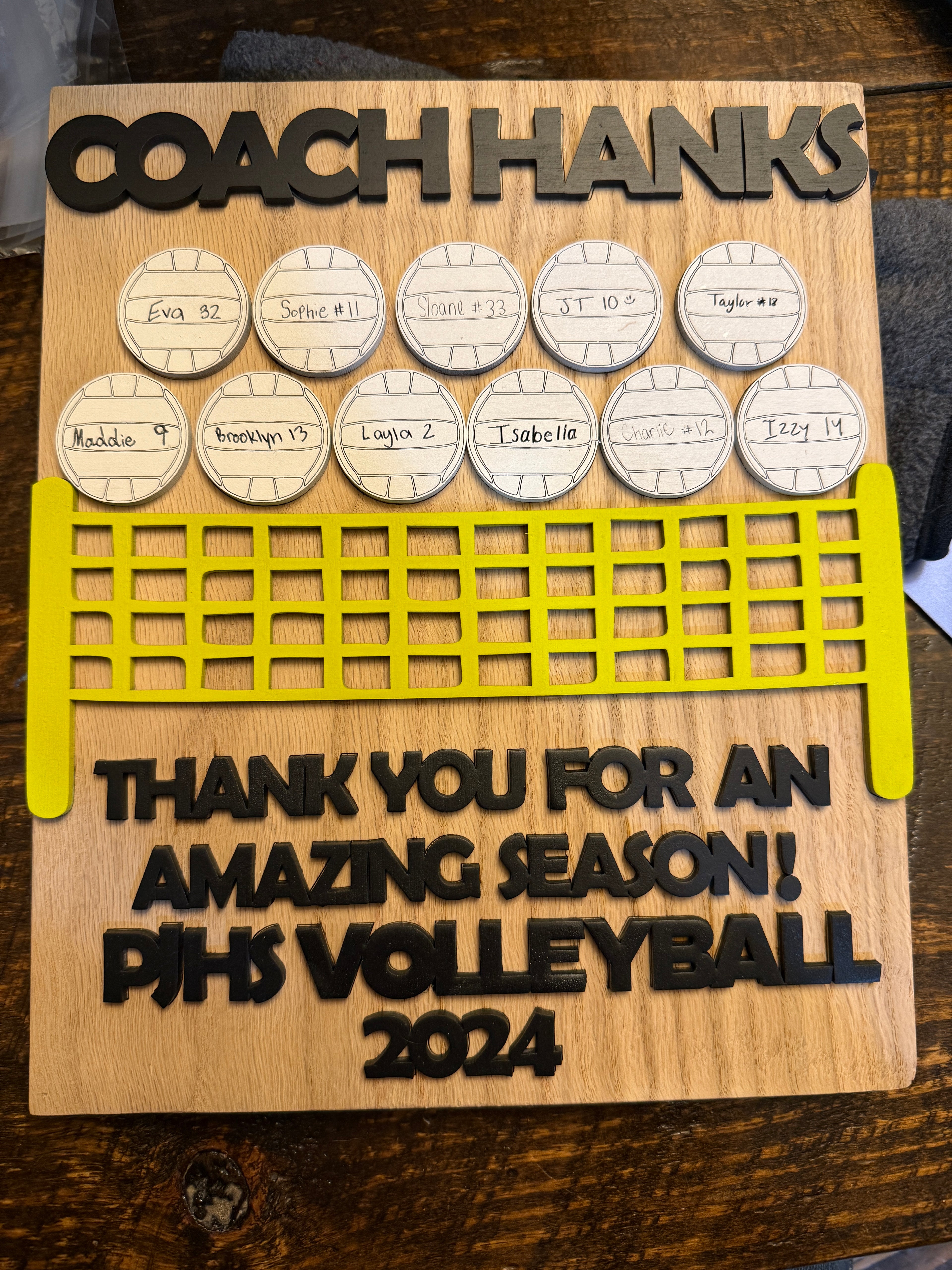 Wooden plaque with engraved text and volleyball design, likely a gift for Coach Hanks.