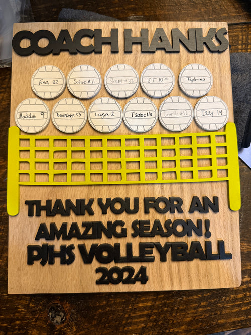 Wooden plaque with engraved text and volleyball design, likely a gift for Coach Hanks.
