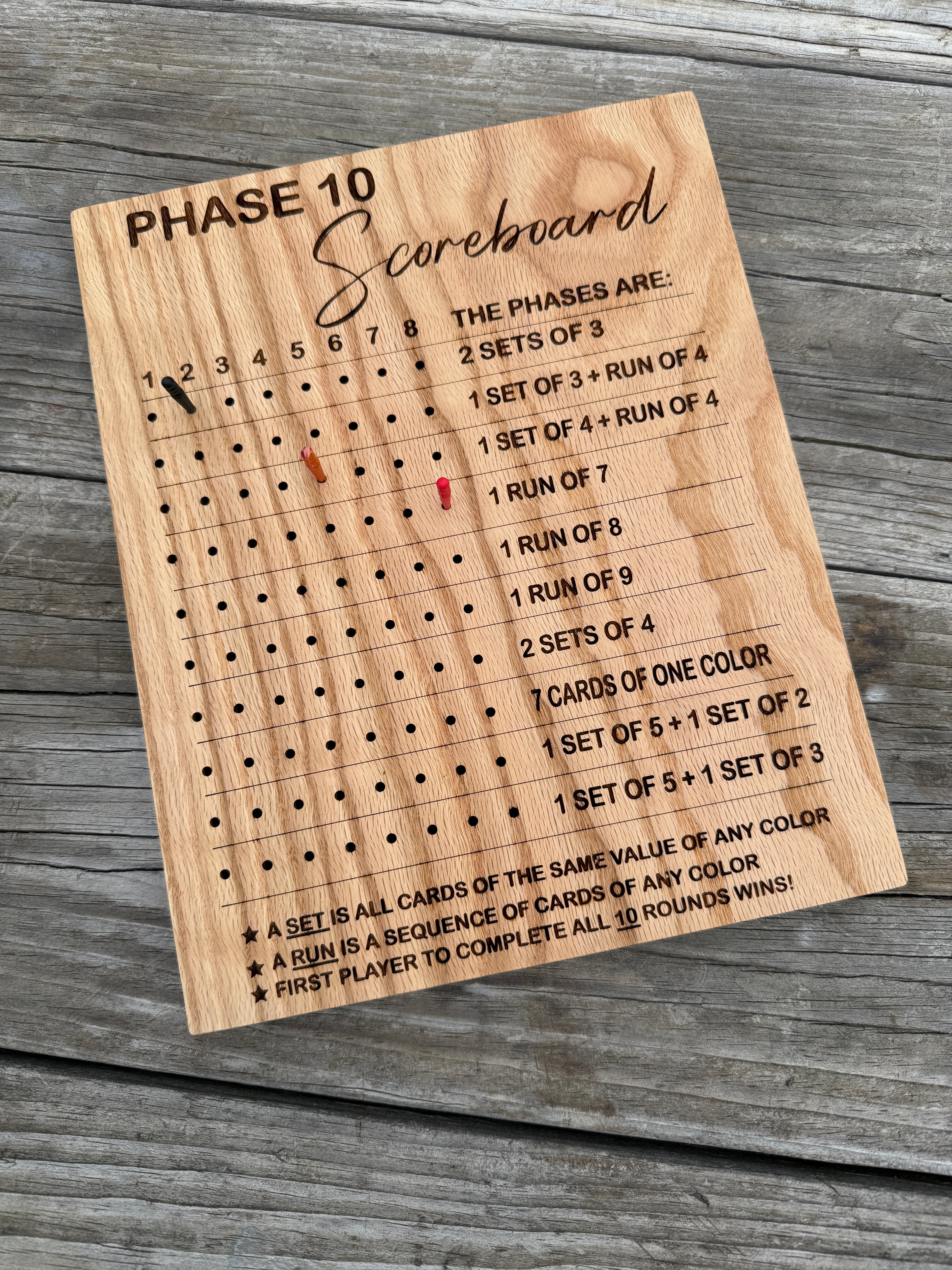 Wooden scoring board with engraved text on a wooden surface