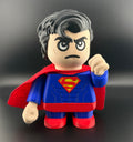 Superman toy figure with red cape and blue suit on a black background