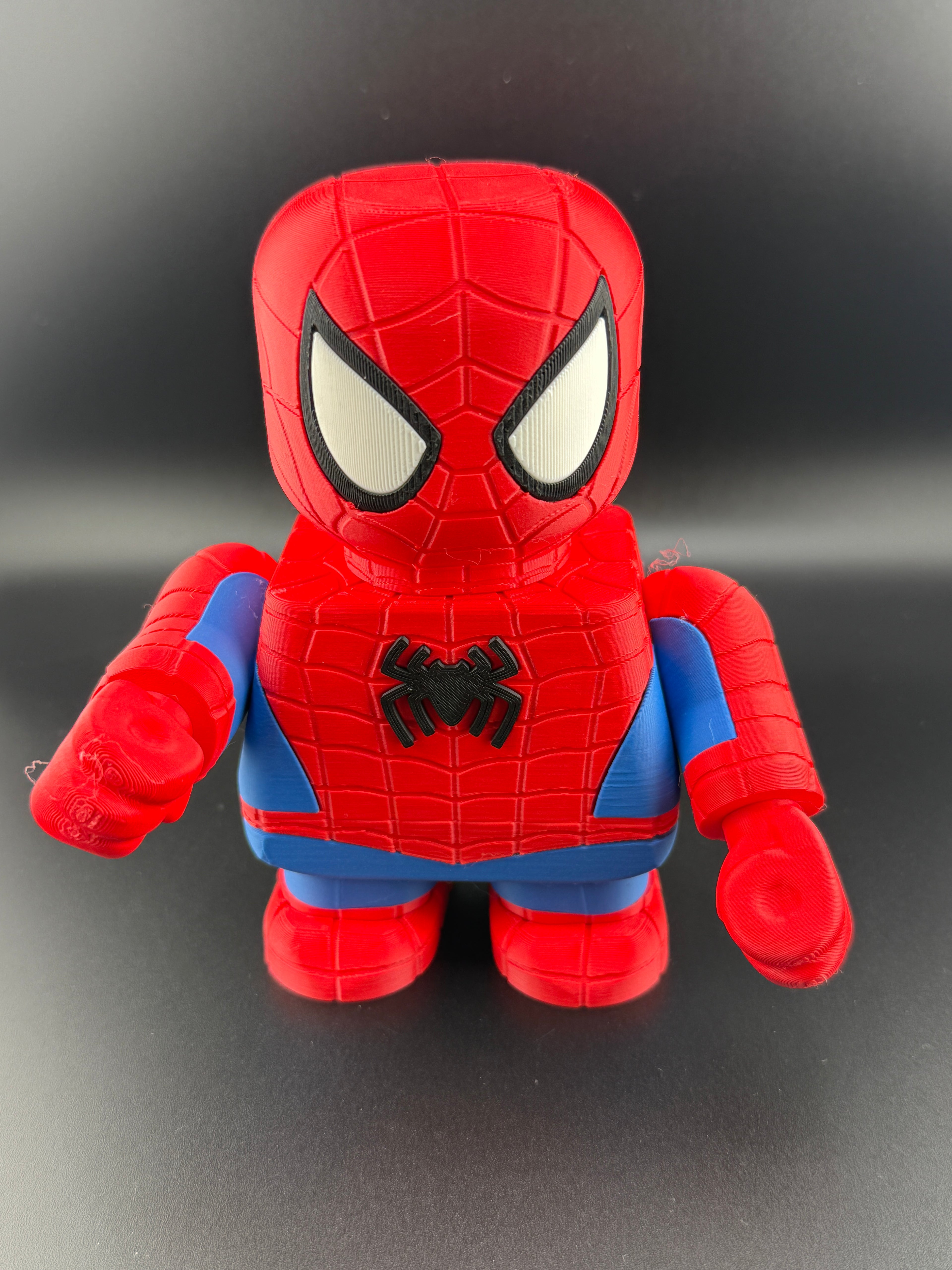 Red and blue toy figure with spider emblem on a black background