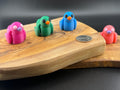 Four small fidget ducks on a wooden surface with a coin for scale.