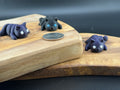 Three small fidget cats  on a wooden surface with a coin for scale.