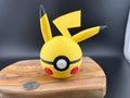 Yellow and black Pikachu inspired character art on wooden platform. 
