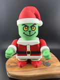 Grinch-like character on a wooden board with a dark background