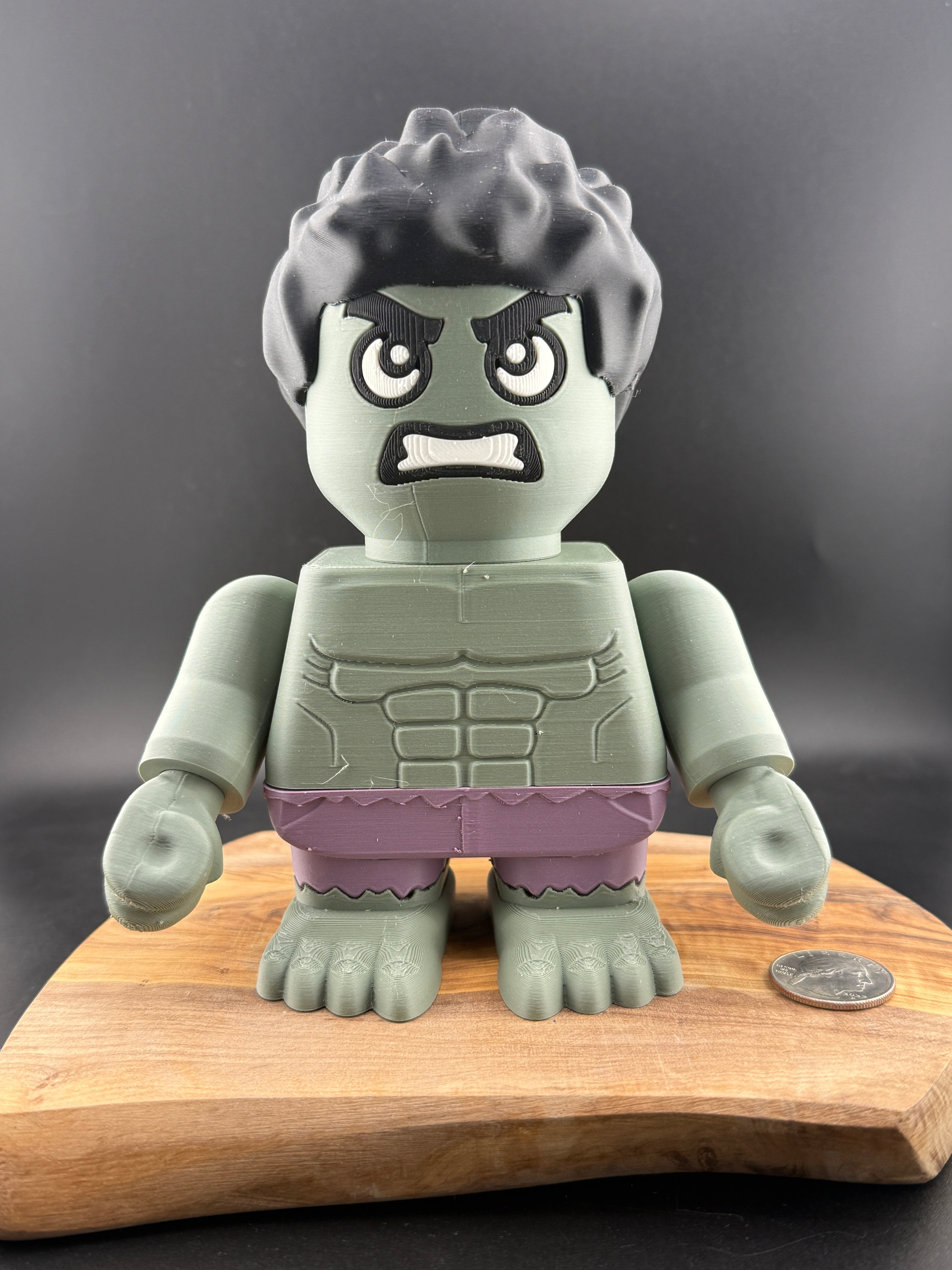 Toy figure with a gray head and purple shorts on a wooden board