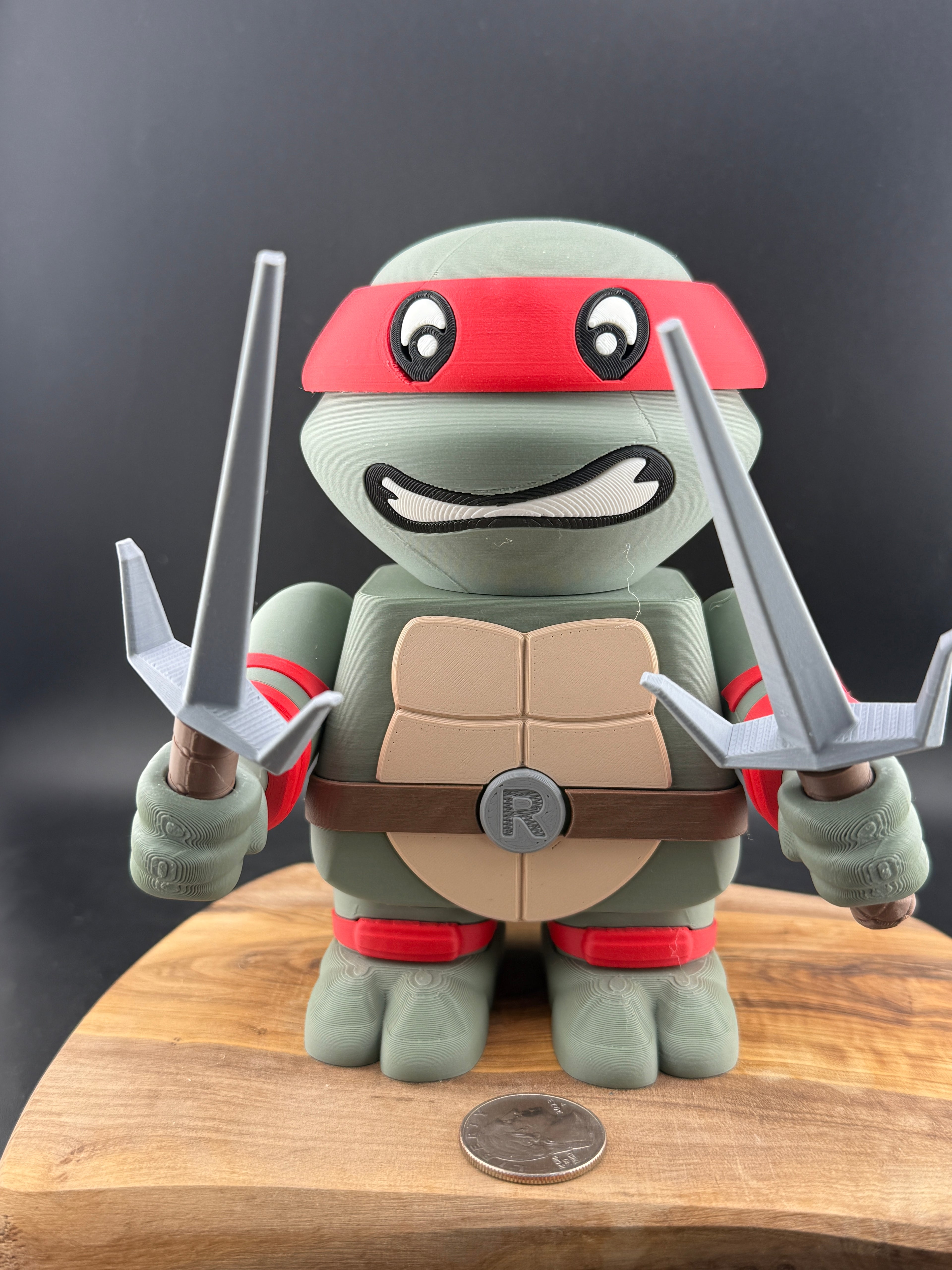 3d Printed turtle with red bandana and weapons on a wooden surface