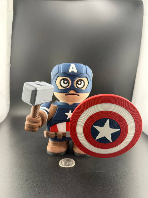 Toy figure of a superhero holding a hammer and shield on a dark background