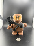 Toy figure of a character with a gun on a dark background