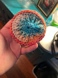 Crocheted disc for washing face on a background hand held. 