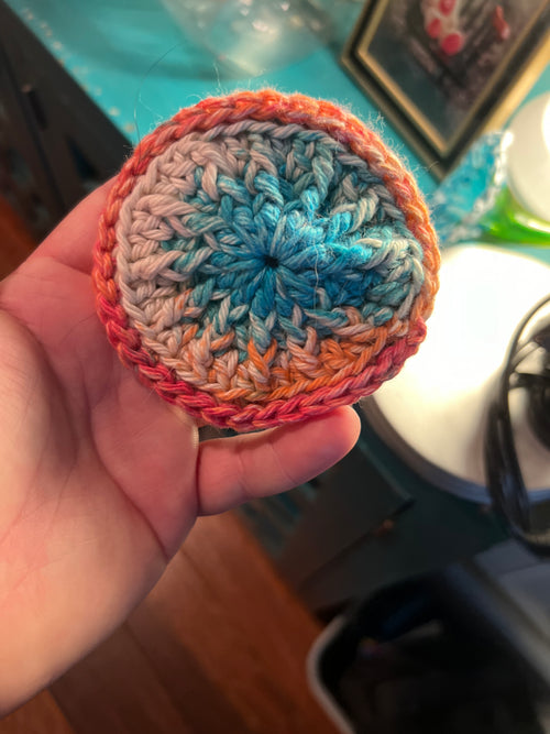 Crocheted disc for washing face on a background hand held. 
